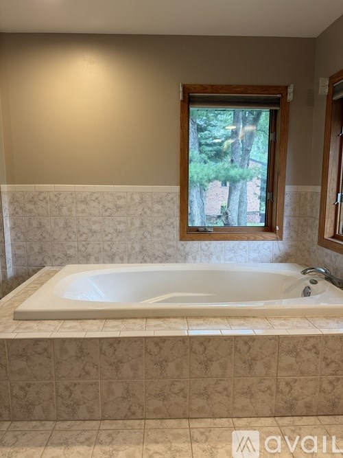 A bathroom with a tub and a window.