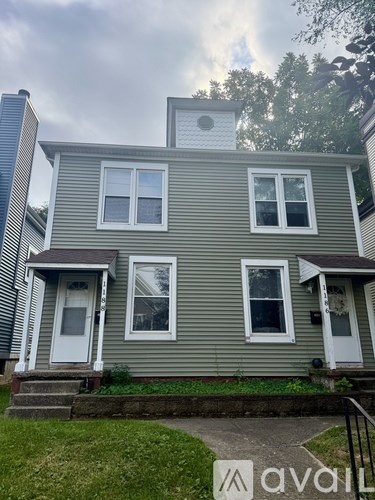 A grey house with a white door and windows.