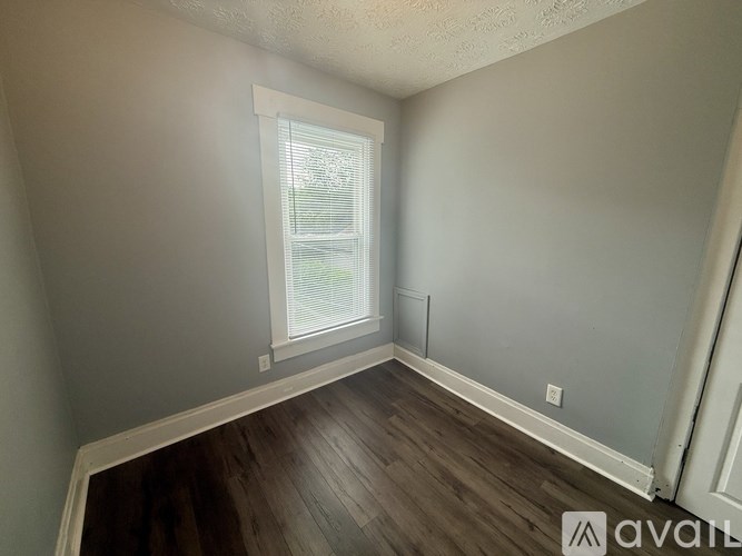 A room with a window and wooden flooring.