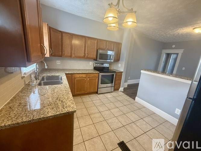 A kitchen with brown cabinets and a granite countertop.