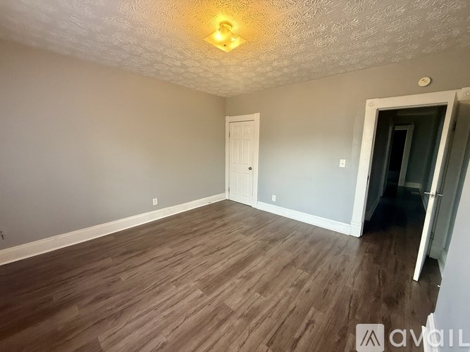 A room with wooden flooring and a ceiling light.