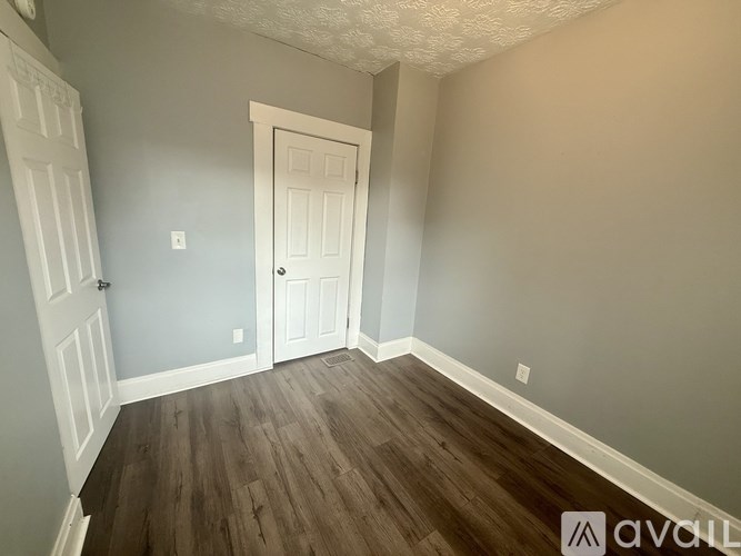 A room with a wooden floor and a white door.