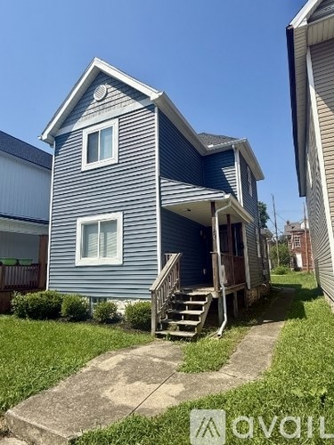 A blue house with a white door and windows.