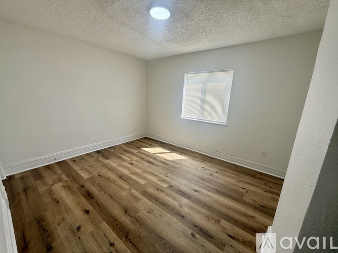 A room with wooden flooring and a window.