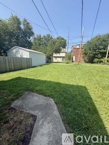 A backyard with a shed and a concrete slab.