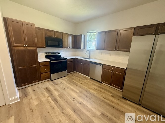 A kitchen with wooden cabinets and a refrigerator.