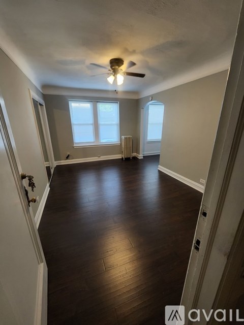 A room with wooden floors and a ceiling fan.