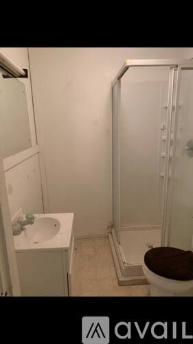 A small bathroom with a toilet, sink, and shower.
