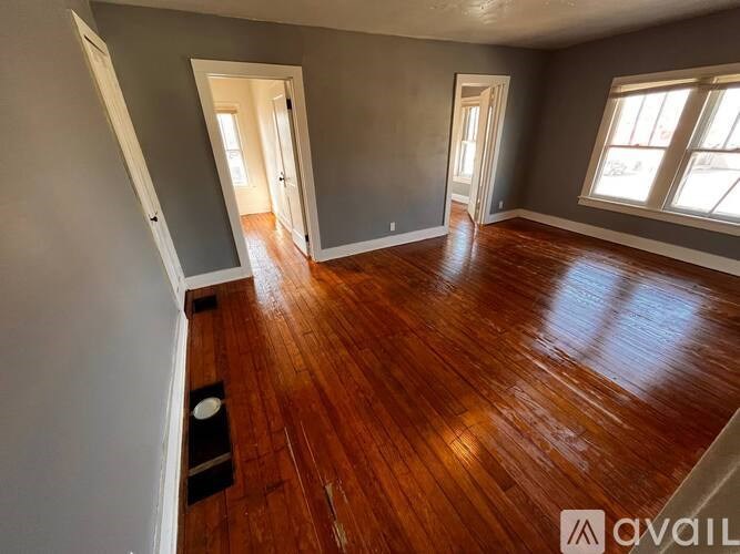 A room with wooden floors and two doors.