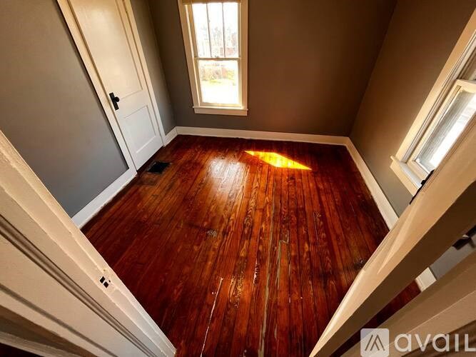 A wooden floor in a room with a window.