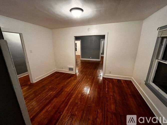 A room with wooden floors and a flat screen TV.