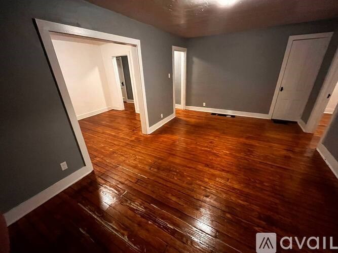 A room with wooden floors and grey walls.