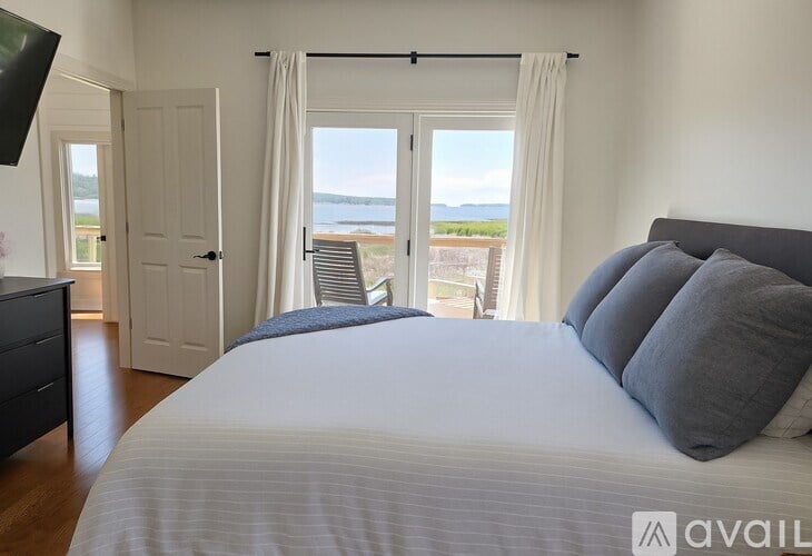 A bedroom with a large bed and a view of the water.