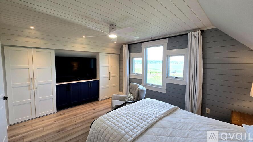 A bedroom with a bed, a couch, and a television in a house.