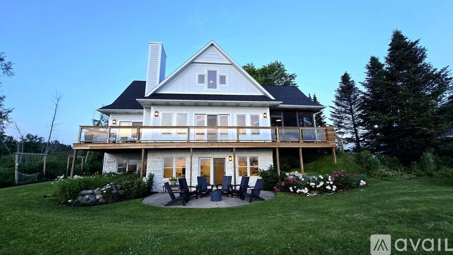 A large house with a balcony and a garden in front.