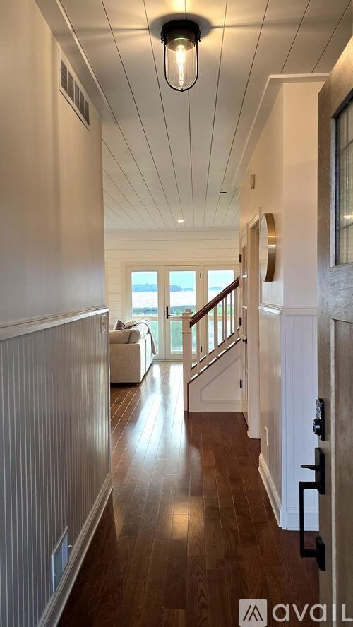 A long hallway with a light on the ceiling and a door on the right.