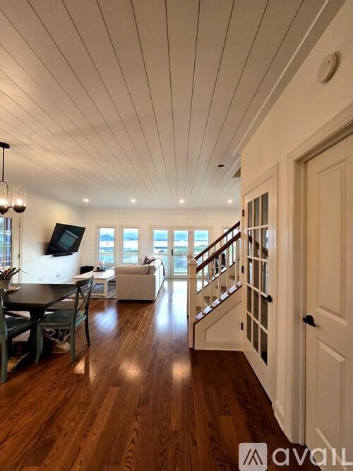 A wooden floor leads to a staircase in a home.
