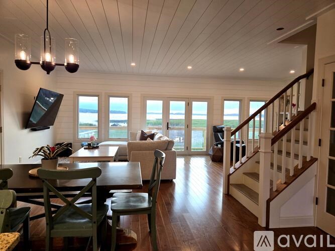 A living room with a wooden floor and a staircase.