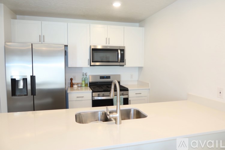 A kitchen with a stainless steel refrigerator, microwave, oven, and sink.