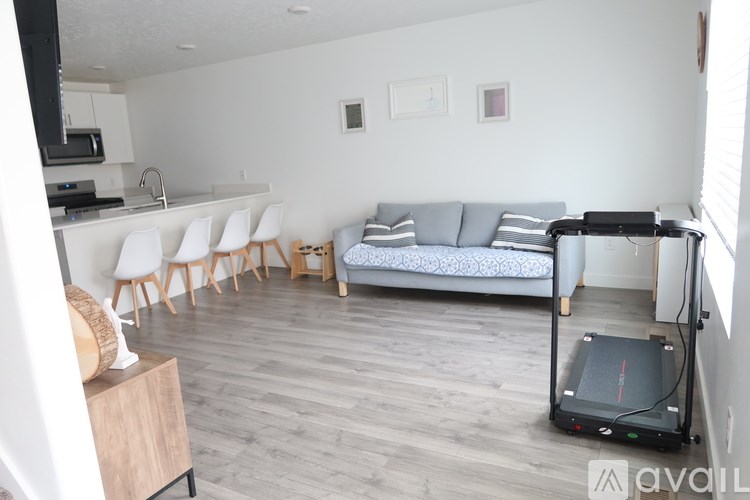 A living room with a couch, chairs, and a vacuum cleaner.