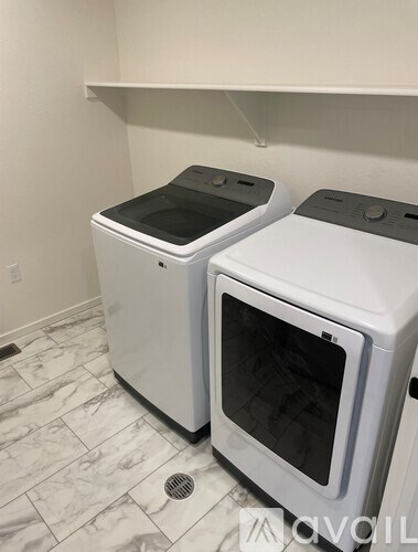 Two white ovens in a kitchen with a marble floor.