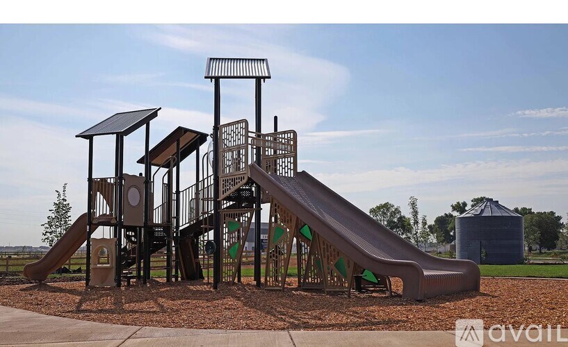 A playground with a slide, swings, and a tower.