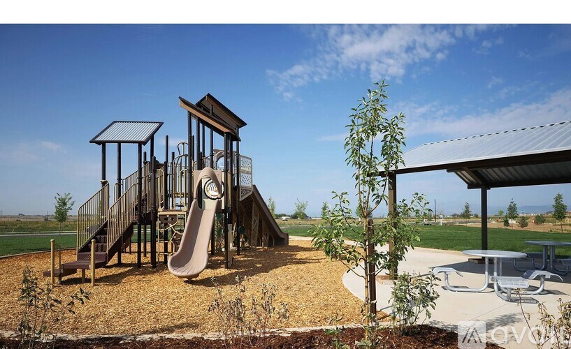 A playground with a slide and a tree.