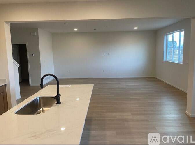A modern kitchen with a sink and wooden flooring.