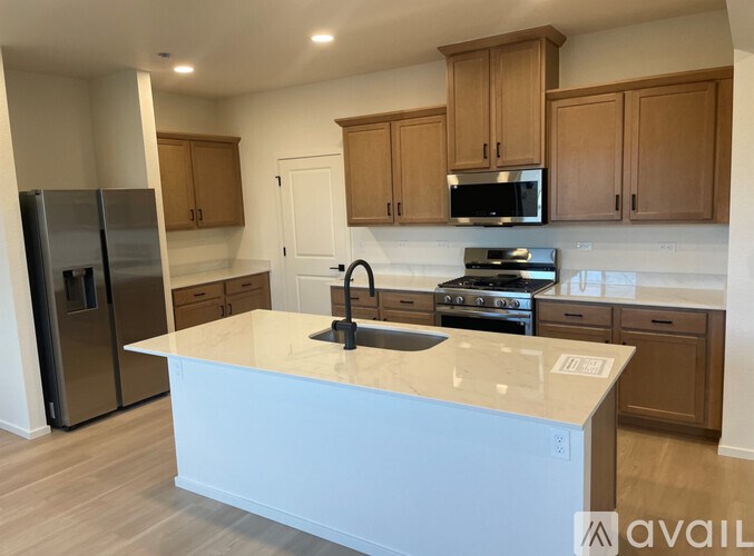 A kitchen with a white island and wooden cabinets.