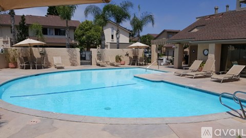 A pool surrounded by lounge chairs and umbrellas.