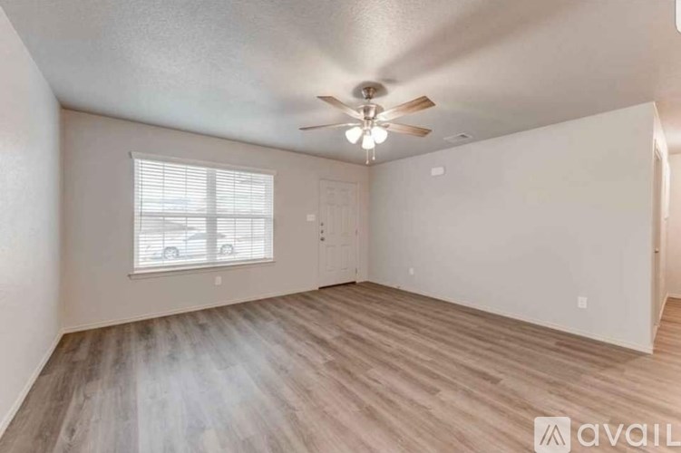 A room with a ceiling fan and a window with blinds.