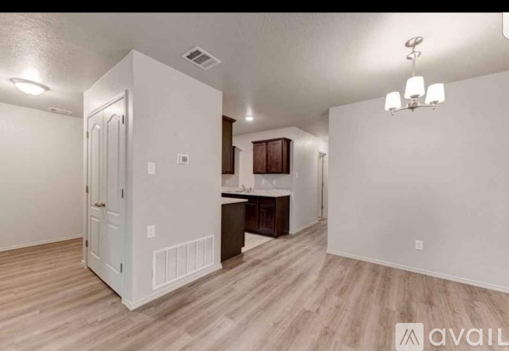 A room with a white door and a wooden floor.