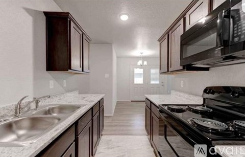 A kitchen with a black stove top oven and a white counter top.