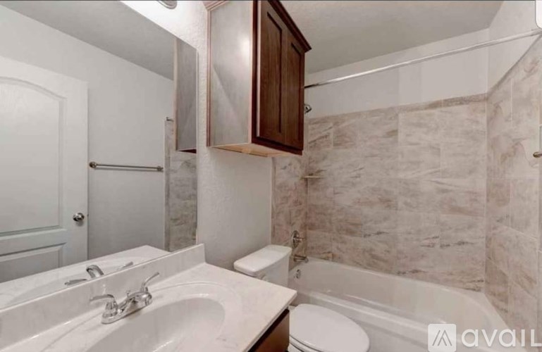 A bathroom with a sink, toilet, and bathtub.