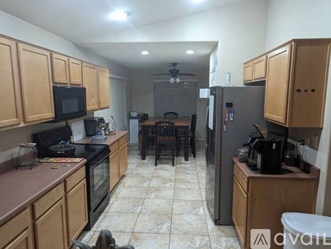 A kitchen with wooden cabinets and a black fridge.