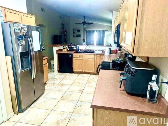 A kitchen with a refrigerator, microwave, and oven.