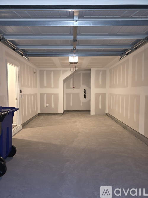 A large, empty storage space with a blue bin on the floor.