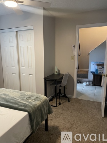A bedroom with a bed, desk, and chair.