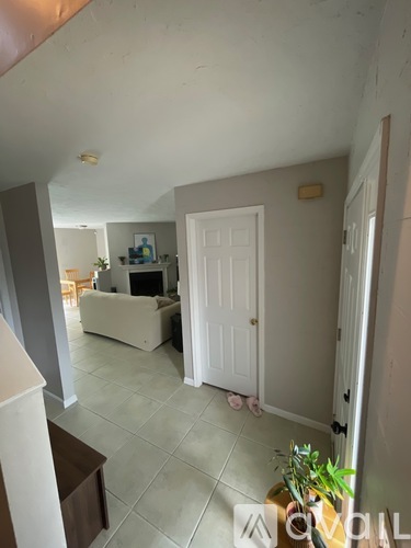 A living room with a white couch and a white door.
