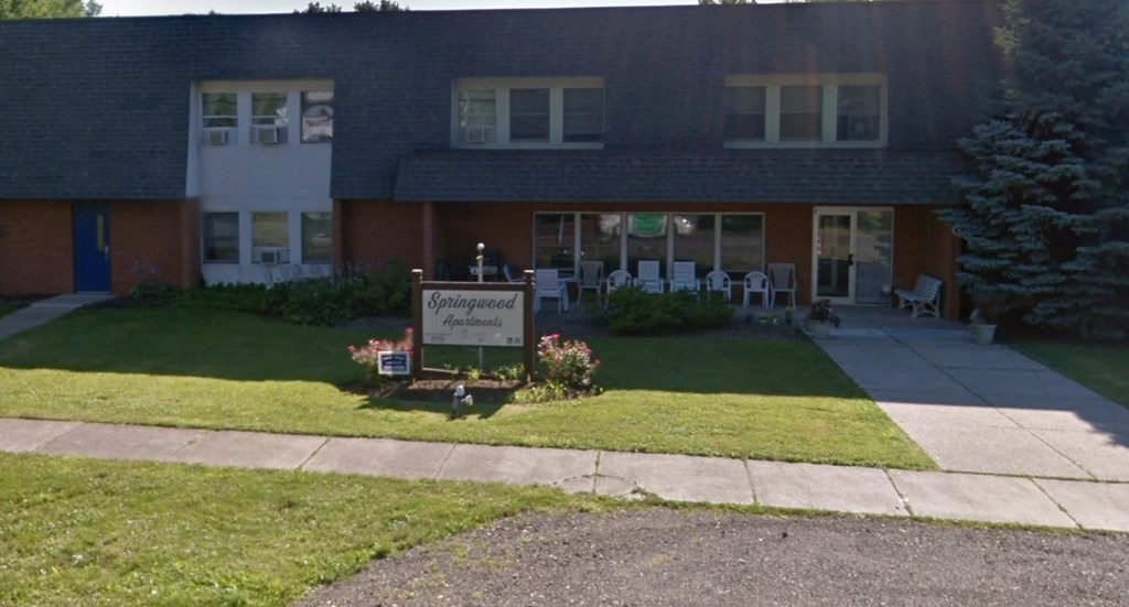 A building with a sign that says "Kensington Manor" in front of it.