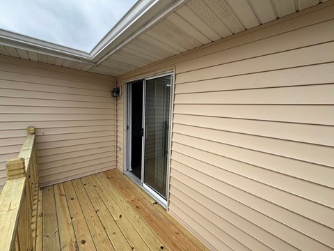 A wooden deck with a sliding glass door.