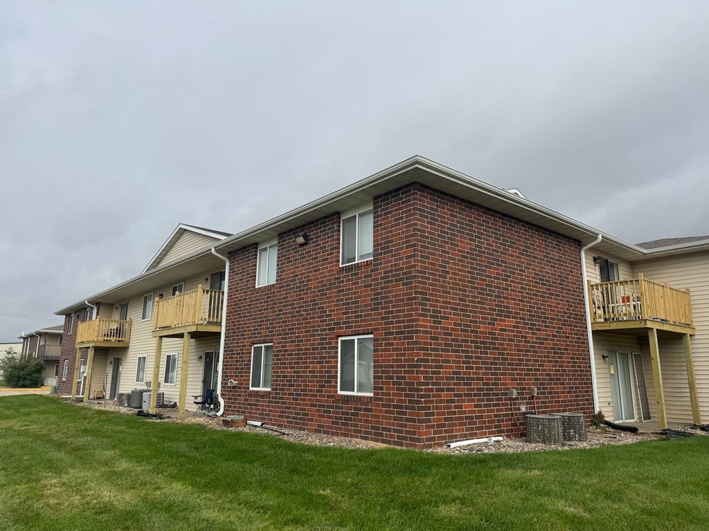 A red brick building with a balcony on the second floor.