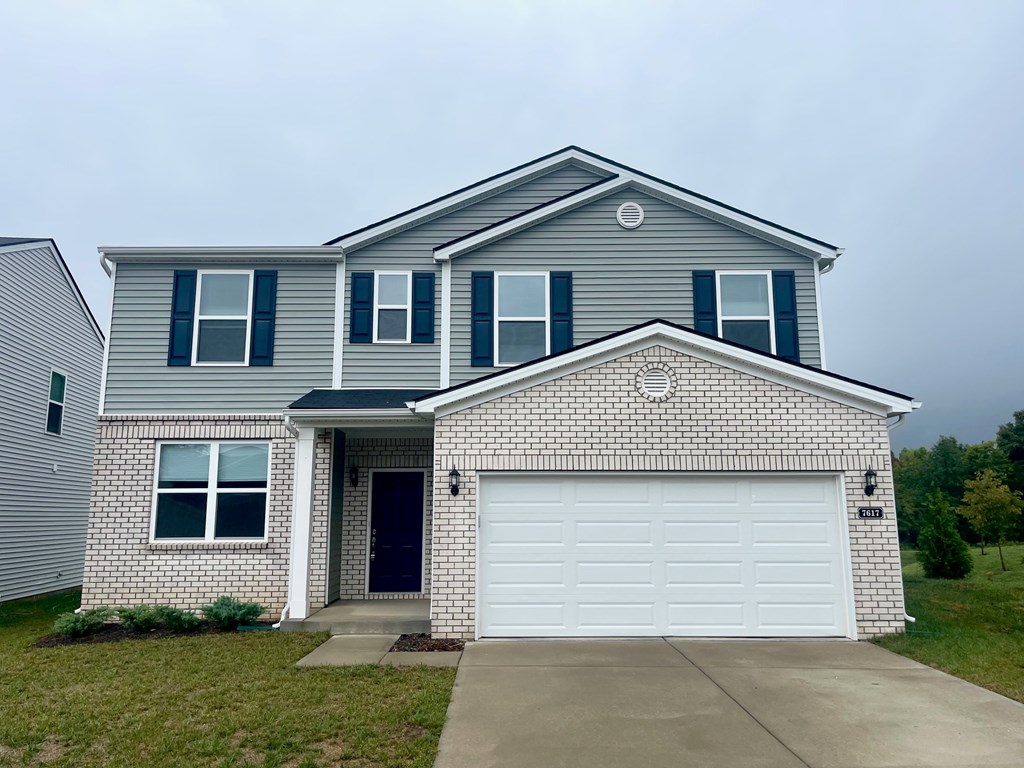 A house with a grey roof and a white garage door.