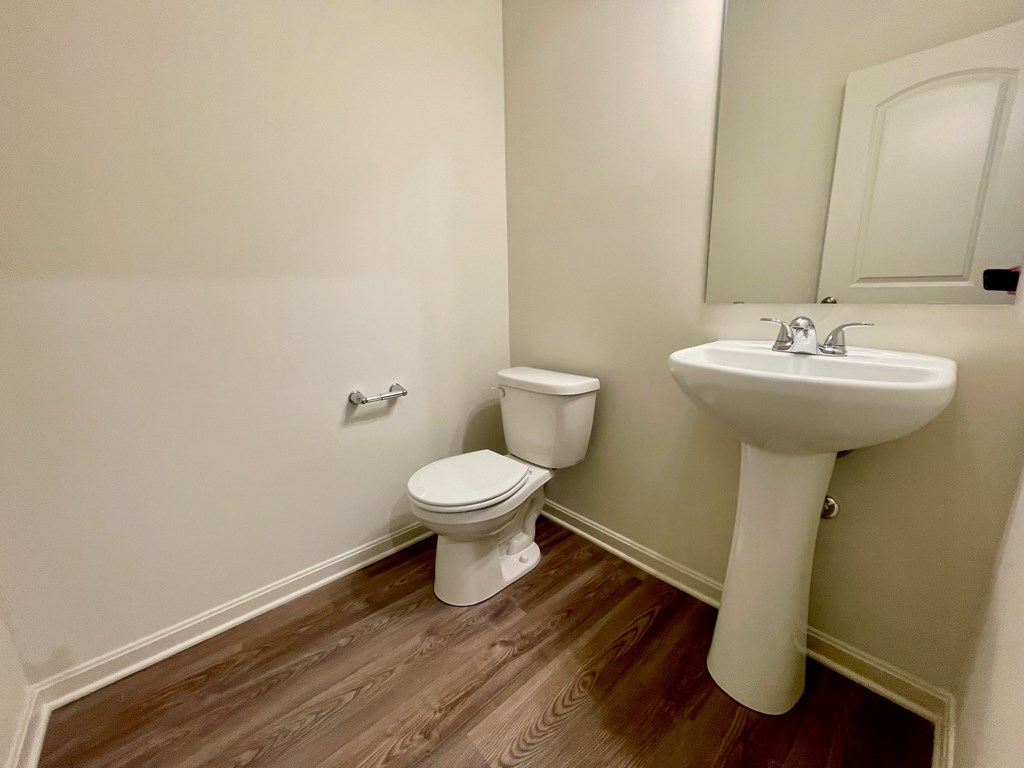 A white toilet and sink in a small bathroom.