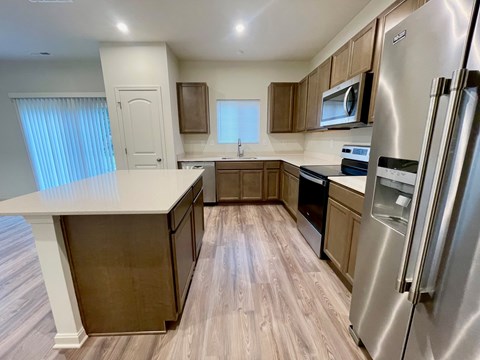 A kitchen with a refrigerator on the right side.