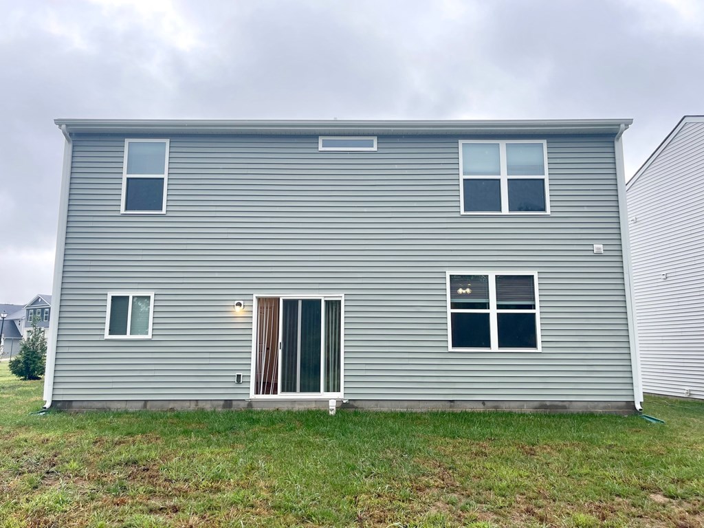 A grey house with a white door and windows.