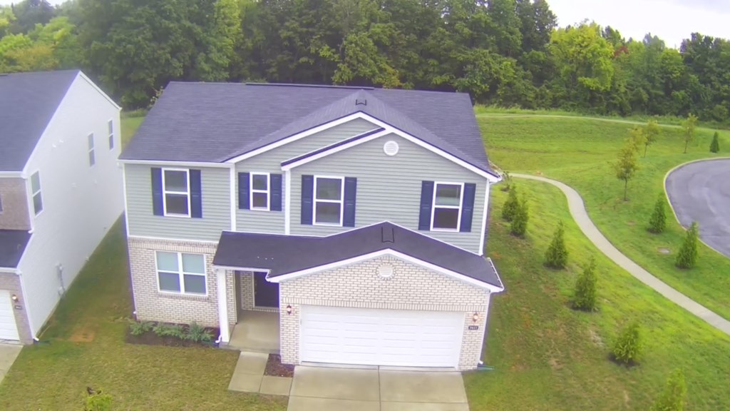 A house with a grey roof and a white garage door.