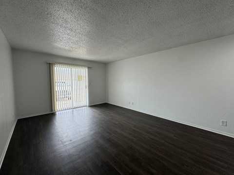 A room with a window and wooden floors.