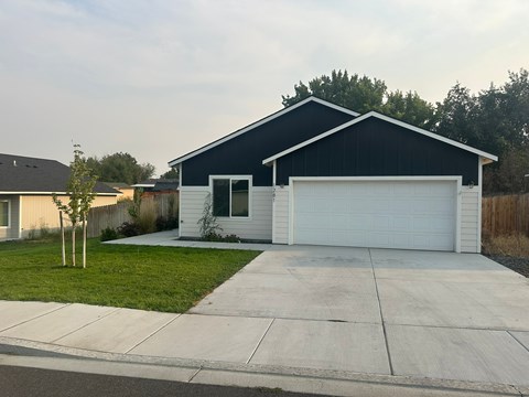 A two-car garage with a white door is attached to a house.