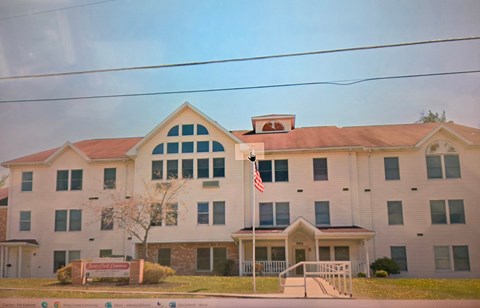 A white building with a red roof and an American flag on top.